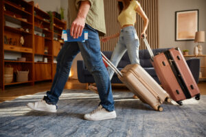 Un homme et une femme entrant dans un logement avec des valises
